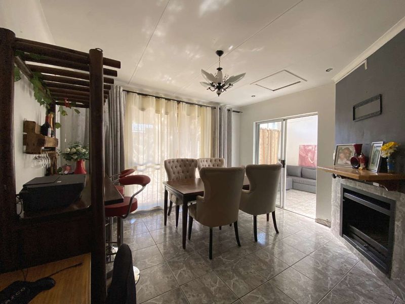 Dining area featuring tiled flooring, a built-in fireplace, and sliding glass doors providing access to an outdoor patio space.