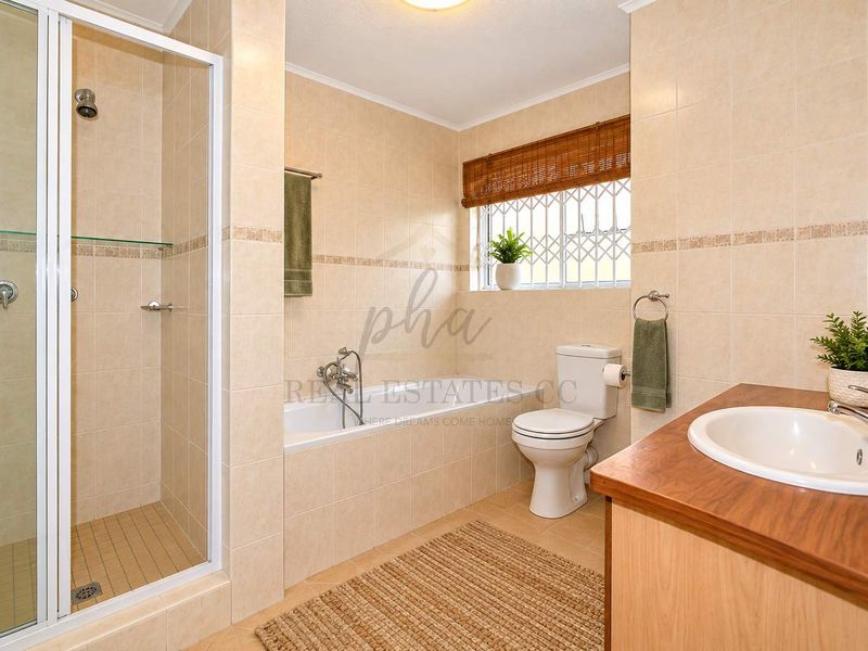 A well-maintained bathroom featuring a separate shower enclosure, built-in bathtub, toilet, and a vanity cabinet with a drop-in sink.