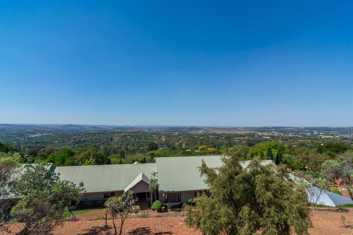 An elevated aerial view of the property showcasing the expansive roof structure and the surrounding landscape and valley views.