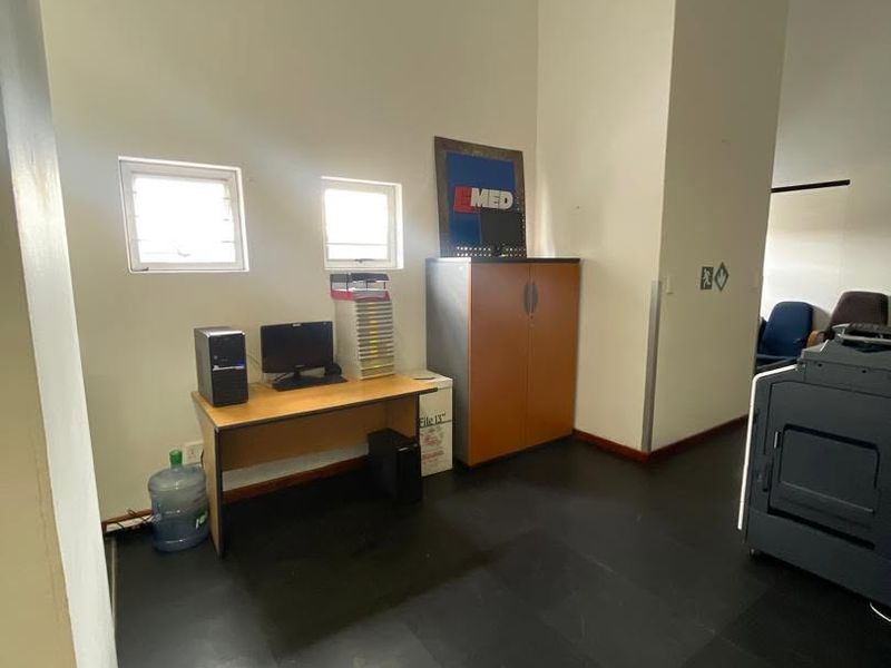 A functional office space featuring vinyl flooring and dual casement windows, providing a practical work environment.