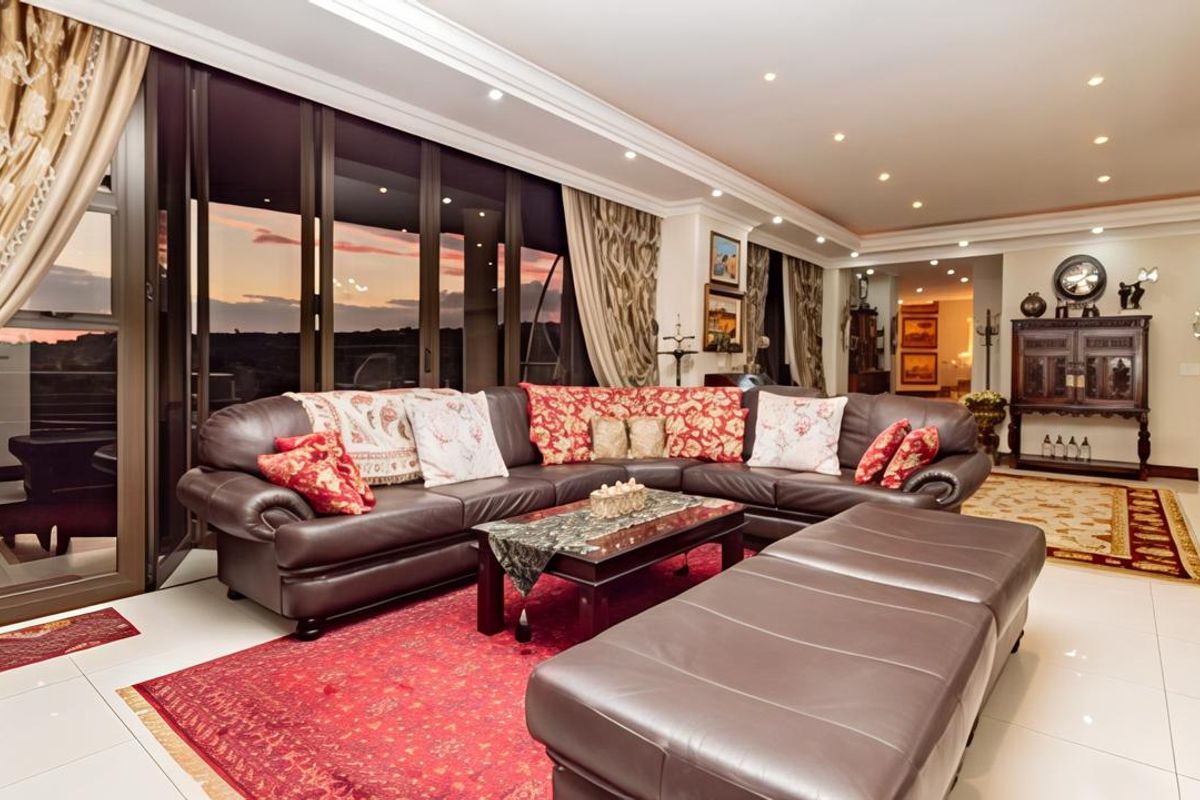 Spacious living area featuring large sliding glass doors that open to an outdoor view, complemented by recessed ceiling lighting and polished tile flooring.