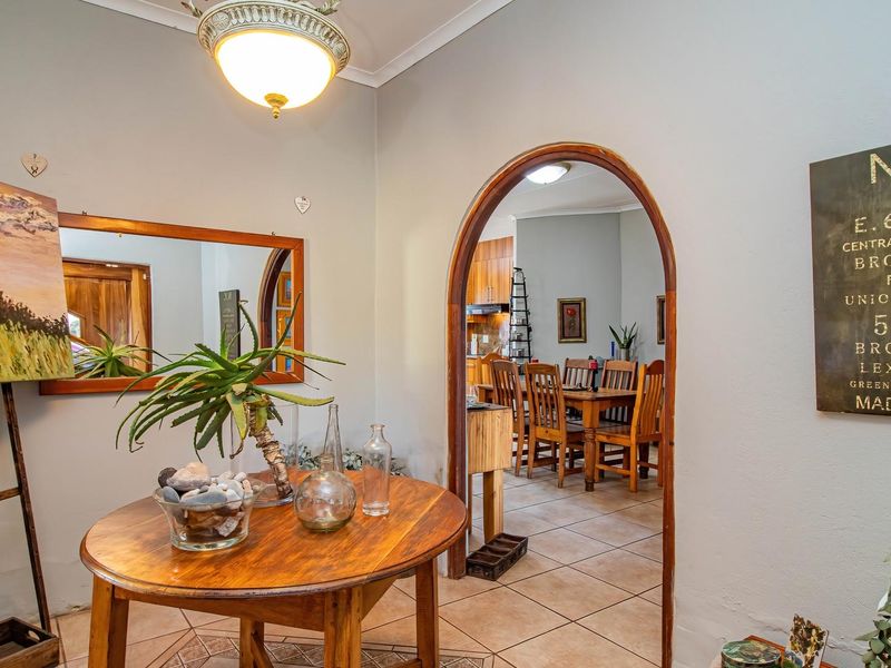 Entrance foyer featuring tiled flooring and a distinctive arched doorway leading into the dining area, providing a warm and welcoming transition between living spaces.