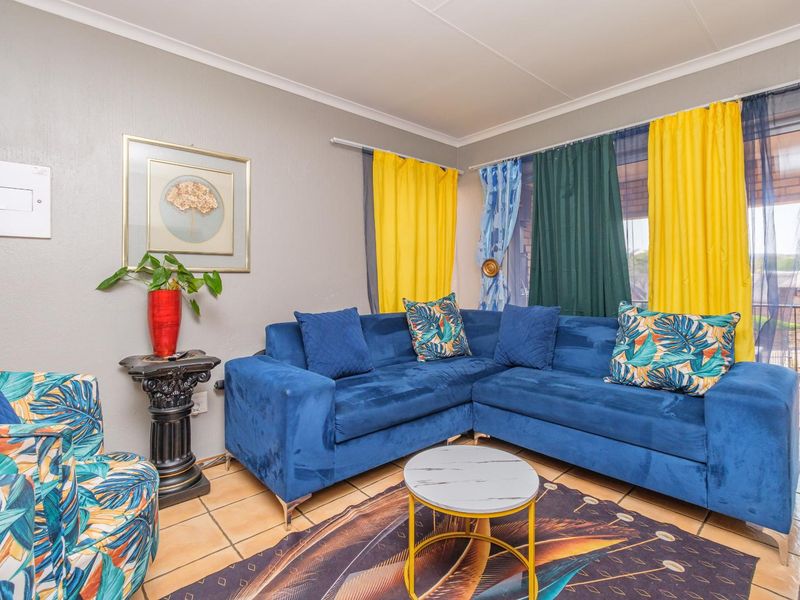 A living room featuring tiled flooring and a sliding glass door providing access to an outdoor area.