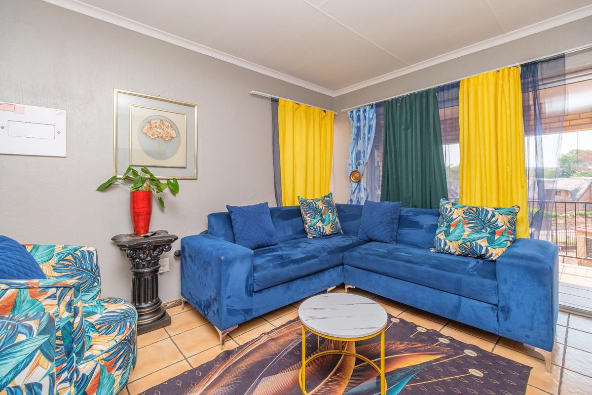 A living room featuring tiled flooring and a sliding glass door providing access to an outdoor area.