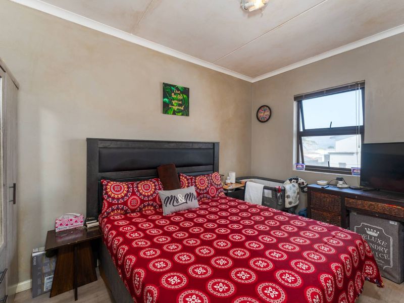 A bedroom featuring a window and ceiling cornice, showing signs of wear on the walls and ceiling requiring cosmetic attention.