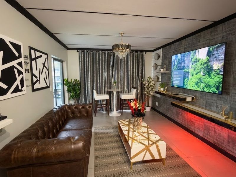 Modern living room featuring a textured feature wall with integrated LED lighting, floating shelving, and a contemporary recessed ceiling design.