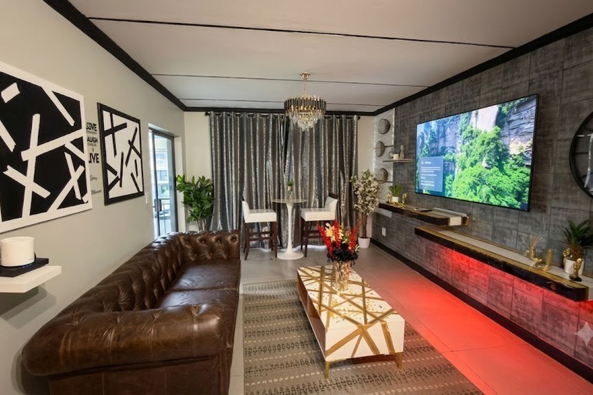 Modern living room featuring a textured feature wall with integrated LED lighting, floating shelving, and a contemporary recessed ceiling design.