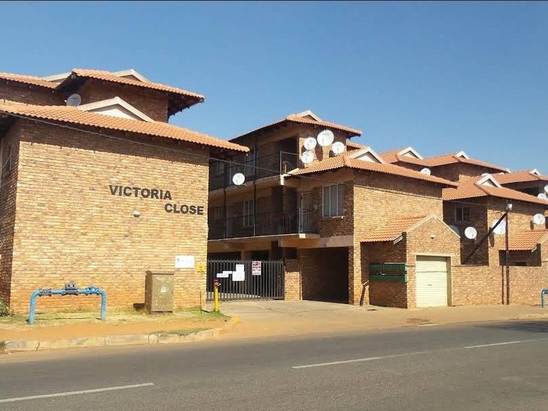 Street view of the Victoria Close apartment complex, featuring face brick construction, tiled roofing, and secure gated access.