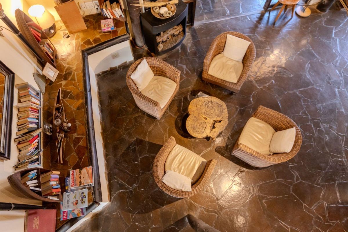 A cozy living area featuring rustic stone flooring and a built-in fireplace, creating a warm and inviting atmosphere within the lodge.