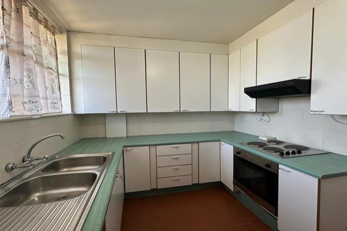 A functional kitchen featuring laminate countertops, built-in cabinetry, a double bowl sink, and integrated oven with electric hob.