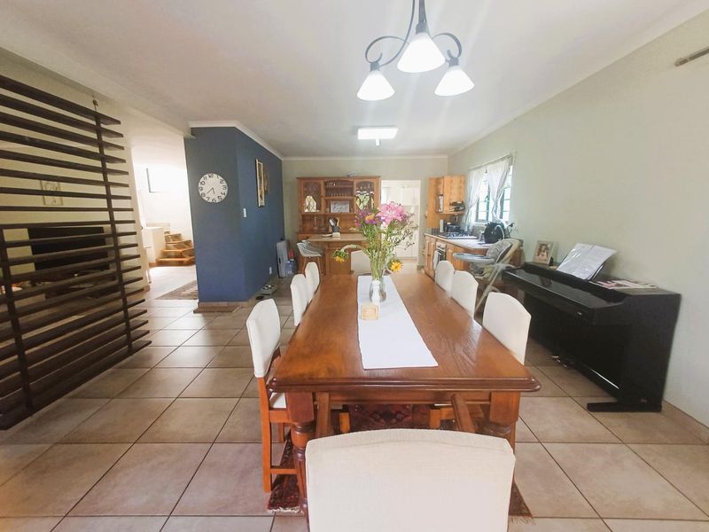 Open-plan dining and kitchen area featuring tiled flooring, a timber slat room divider, and functional built-in cabinetry.