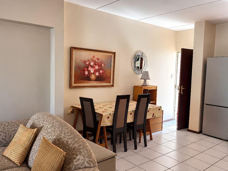 Open-plan living and dining area featuring tiled flooring and direct access to the exterior, creating a functional and connected living space.