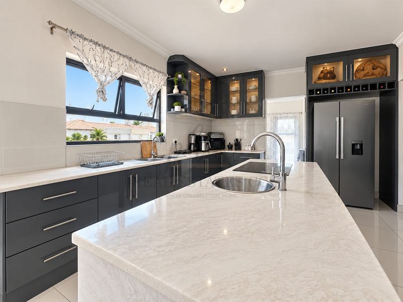 Modern kitchen featuring dark cabinetry, a large central island with quartz countertops, integrated appliances, and ample storage space with glass-front display cabinets.