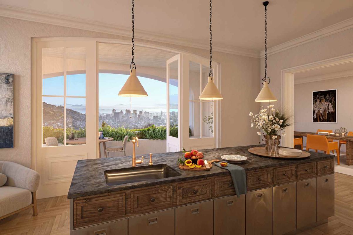 A modern kitchen island with a stone countertop and brass fixtures, featuring large french doors that open to a scenic city view.