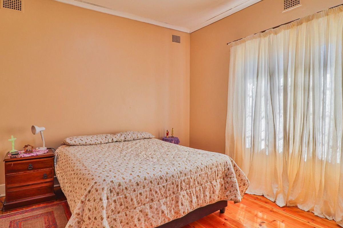 A bedroom featuring polished hardwood flooring and neutral wall finishes, offering a blank canvas for modern interior design updates.