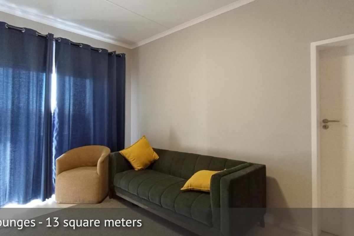A neutrally painted living room featuring a large window with curtains and a standard interior door.