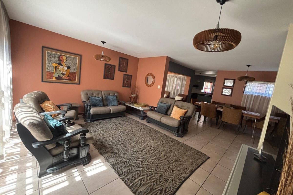 Spacious open-plan living and dining area featuring neutral tiled flooring and warm-toned walls, providing a versatile layout for family living and entertaining.
