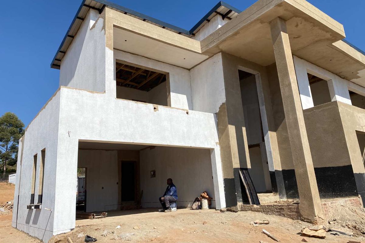 A double-storey residential property currently under construction, featuring a plastered facade, concrete columns, and an incomplete exterior structure.
