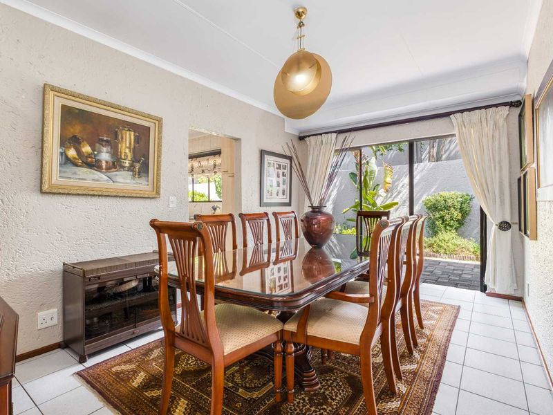 Dining room featuring tiled flooring, coved ceiling, and a sliding glass door providing direct access to the rear patio and garden area.