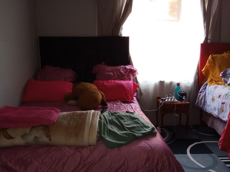 A bedroom featuring a window with curtains, providing natural light to the space.
