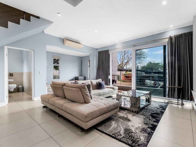 Spacious living room featuring tiled flooring, recessed downlights, a split-system air conditioner, and large sliding glass doors leading to an outdoor area.