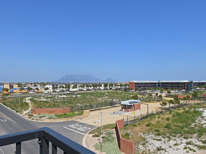 Elevated view overlooking the surrounding estate, security access point, and distant mountain landscape.