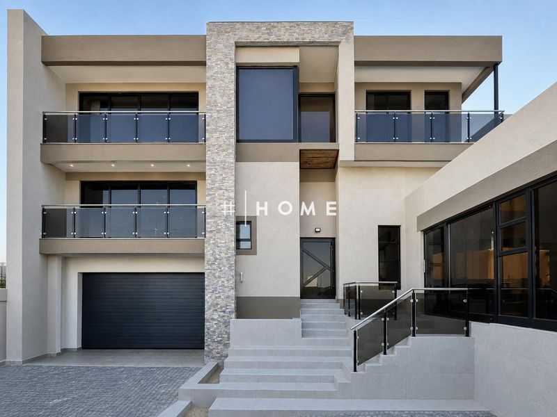 Modern multi-story residential facade featuring stone cladding, glass balustrades, and a sleek sectional garage door.