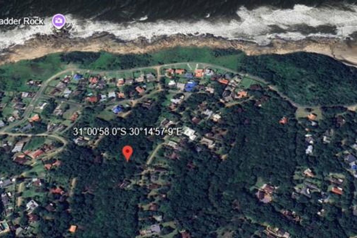 An aerial view of a residential area near the coastline, showing the surrounding landscape and proximity to the ocean.