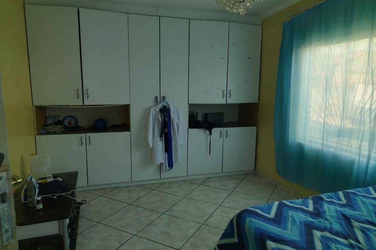Bedroom featuring extensive built-in floor-to-ceiling cabinetry and tiled flooring.