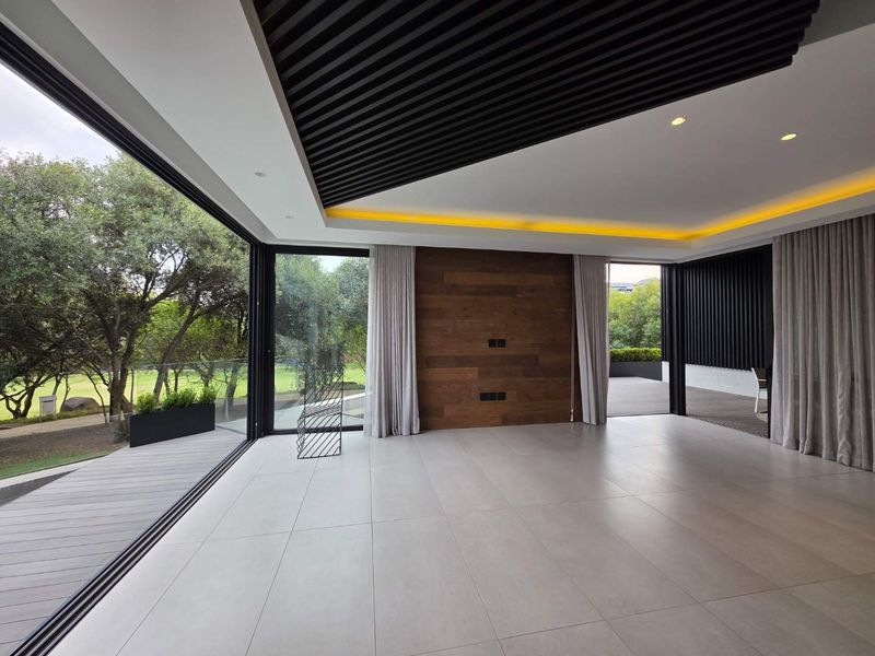 Spacious modern living area featuring high-end finishes, timber ceiling and wall accents, recessed lighting, and seamless flow to an outdoor timber deck.
