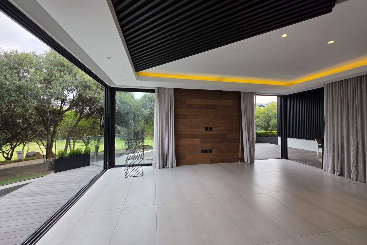 Spacious modern living area featuring high-end finishes, timber ceiling and wall accents, recessed lighting, and seamless flow to an outdoor timber deck.