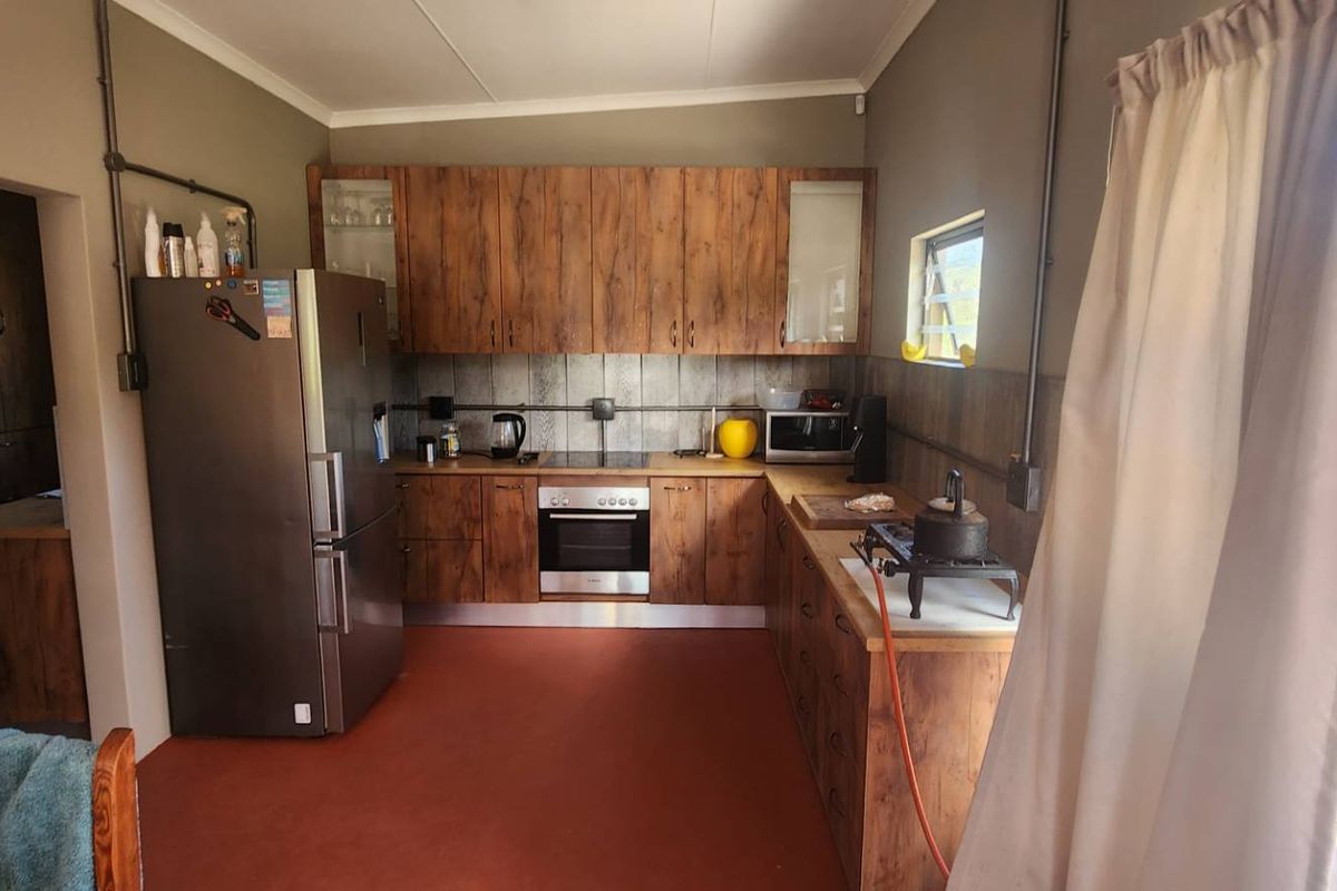 Functional kitchen featuring wood-look cabinetry, built-in oven, and direct access to the outdoor patio area.