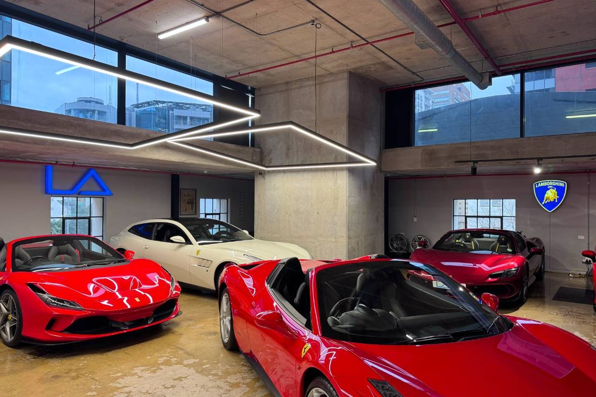 Modern industrial-style garage space featuring exposed concrete ceilings, polished concrete floors, and contemporary linear lighting fixtures.