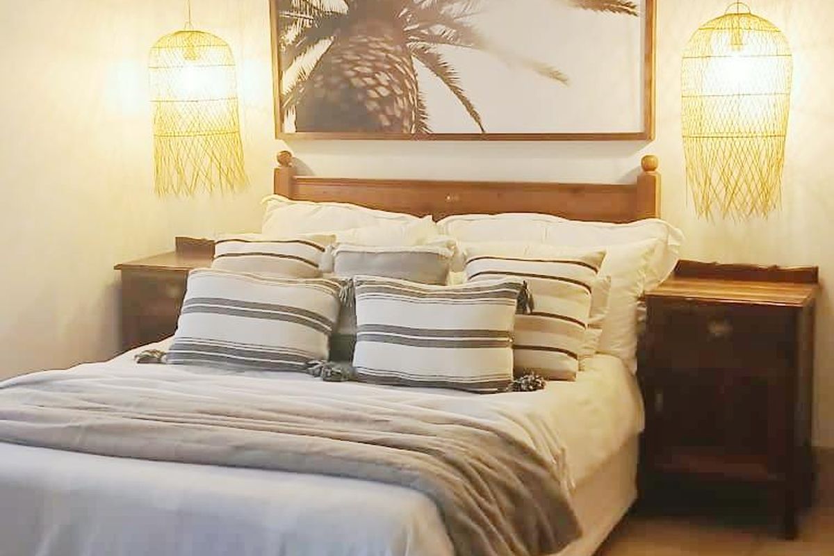 A cozy bedroom featuring tiled flooring and a ceiling fan, providing a comfortable and functional sleeping space.
