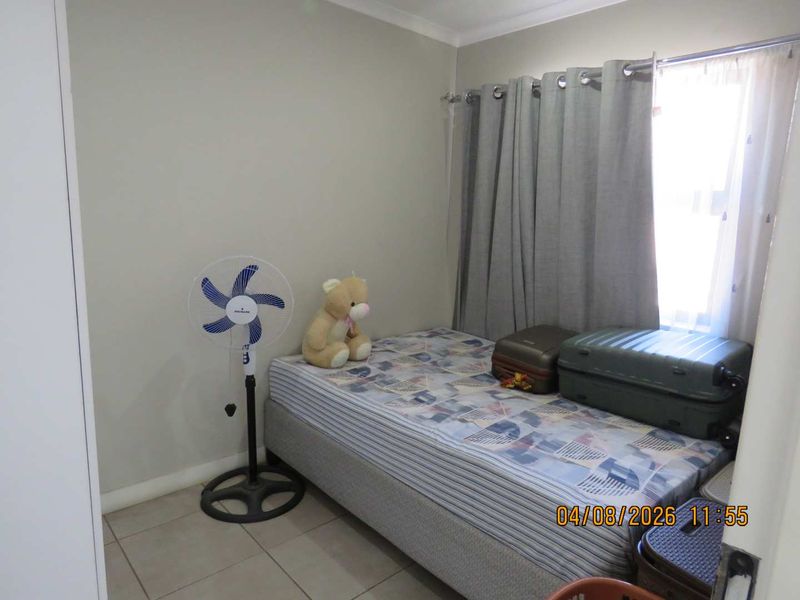 A functional bedroom featuring tiled flooring and a built-in cupboard, providing a neutral space ready for personalization.
