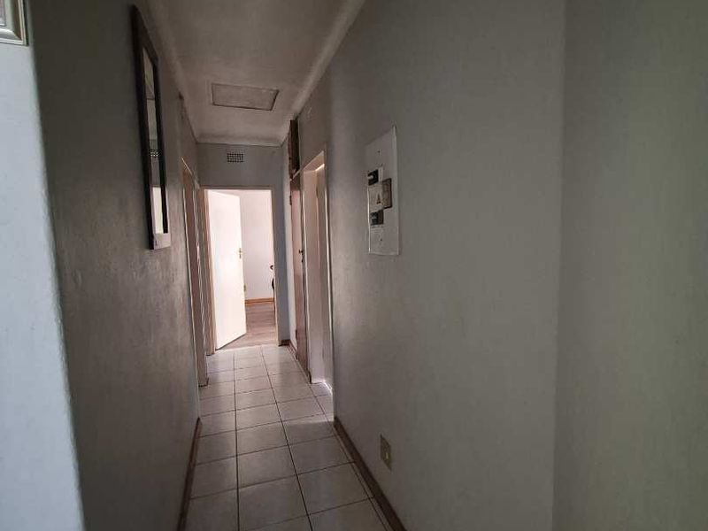 A functional hallway featuring tiled flooring and access to multiple rooms, providing a clean and neutral transition space within the townhouse.