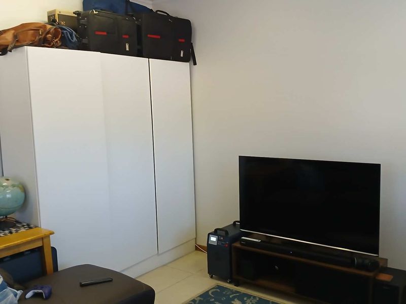 A bedroom featuring a built-in wardrobe and tiled flooring, providing functional storage space within the apartment.