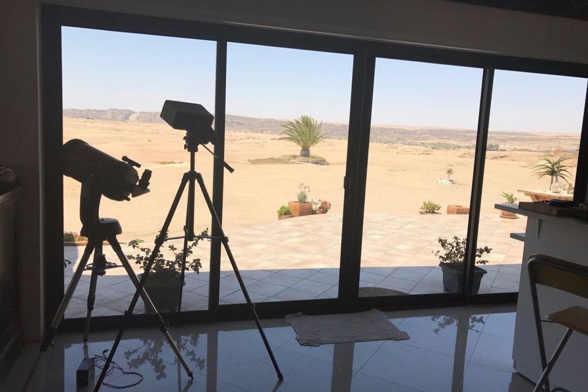 Spacious interior living area featuring large floor-to-ceiling sliding glass doors that provide expansive views of the surrounding desert landscape and outdoor patio.
