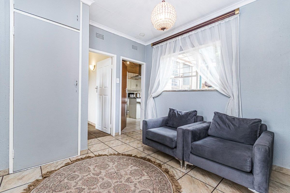 A functional living area featuring tiled flooring, built-in storage cabinetry, and direct access to the kitchen area.
