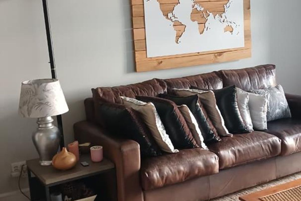 A comfortable living room area featuring neutral wall tones and tiled flooring, providing a versatile space for relaxation.