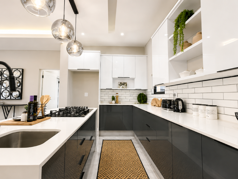 Modern kitchen featuring a central island with gas hob, sleek two-tone cabinetry, quartz countertops, and a stylish subway tile backsplash.