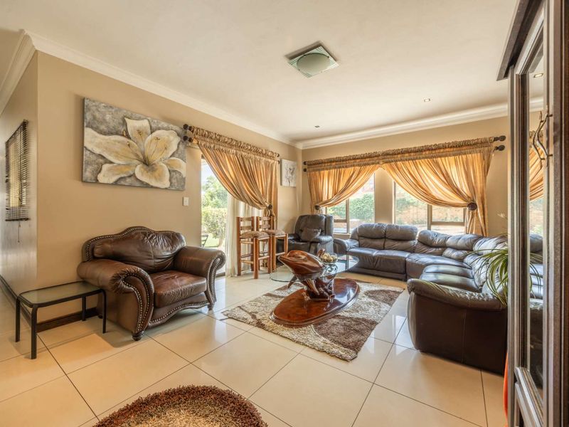 Spacious living room featuring large format floor tiles, neutral wall tones, and sliding glass doors providing natural light and access to the outdoor area.