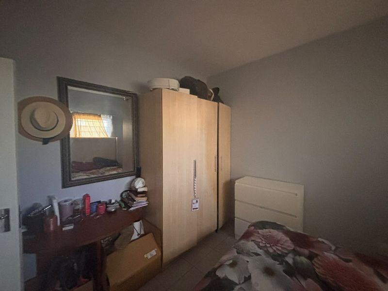 A bedroom featuring a built-in wardrobe and tiled flooring, offering functional storage space within the apartment.