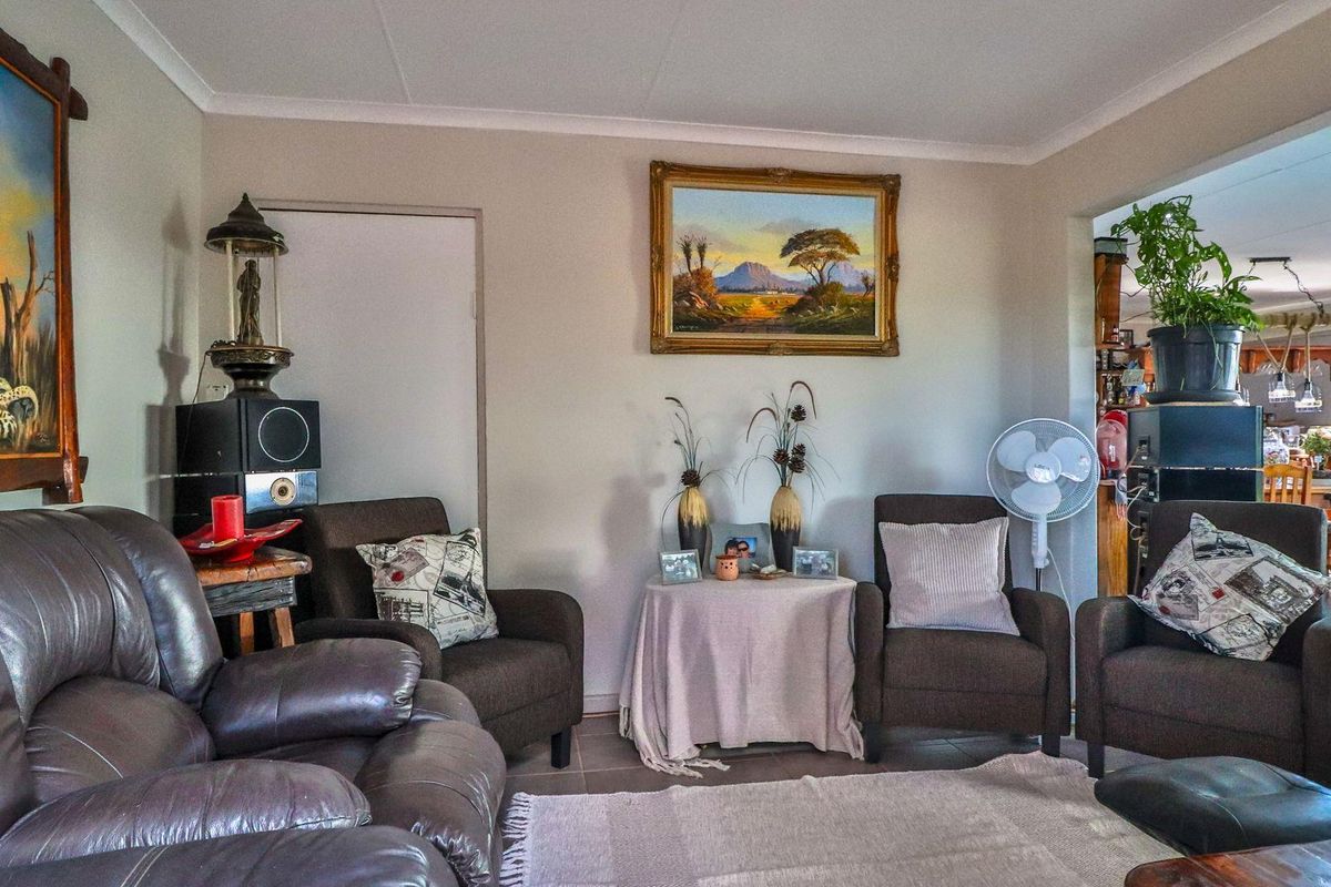 A comfortable living room area featuring tiled flooring and neutral wall finishes, with an open-plan layout connecting to the adjacent dining space.