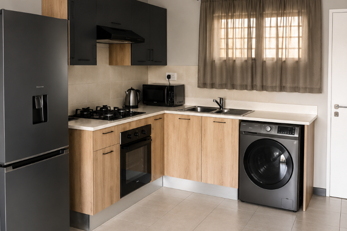 Modern kitchen featuring light wood-tone cabinetry, contrasting dark upper cabinets, gas hob, built-in oven, and integrated washing machine with neutral tiled flooring.