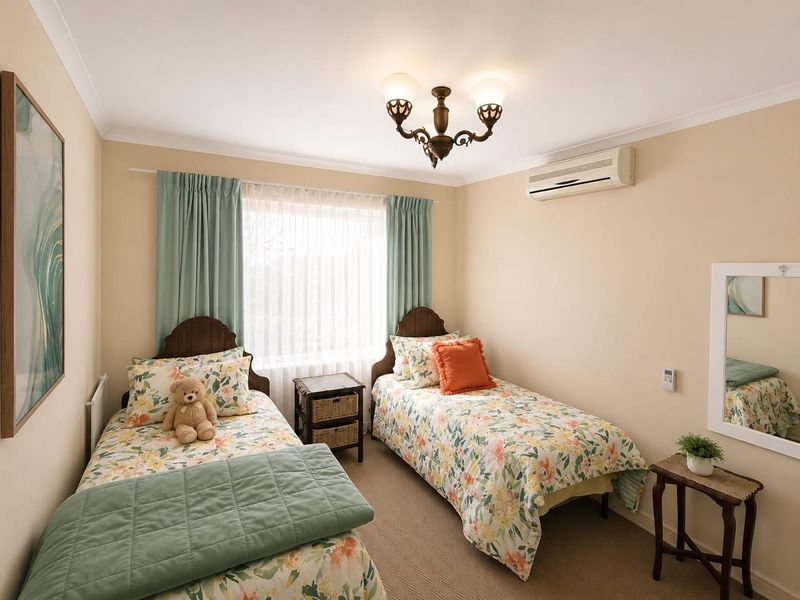 A well-maintained bedroom featuring neutral wall tones, carpet flooring, and a wall-mounted split-system air conditioner.