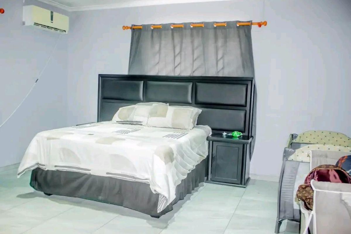 A bedroom featuring tiled flooring and a wall-mounted air conditioning unit.