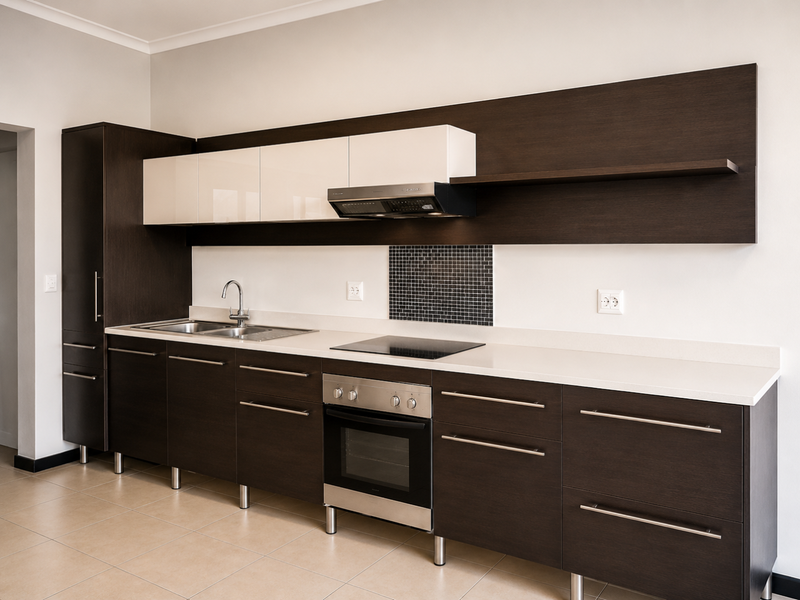 Modern kitchen featuring dark wood cabinetry, contrasting white upper cabinets, stone countertops, integrated stainless steel appliances, and a mosaic tile backsplash.