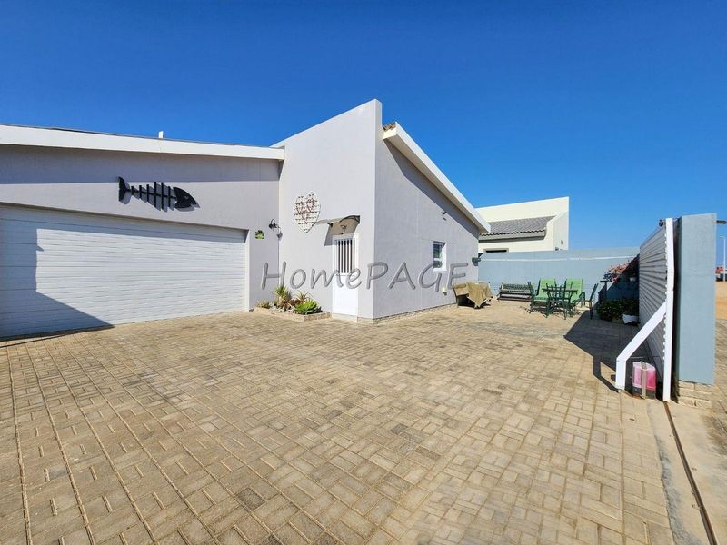 Front exterior view of the property featuring a paved driveway, garage access, and a clean, modern facade.