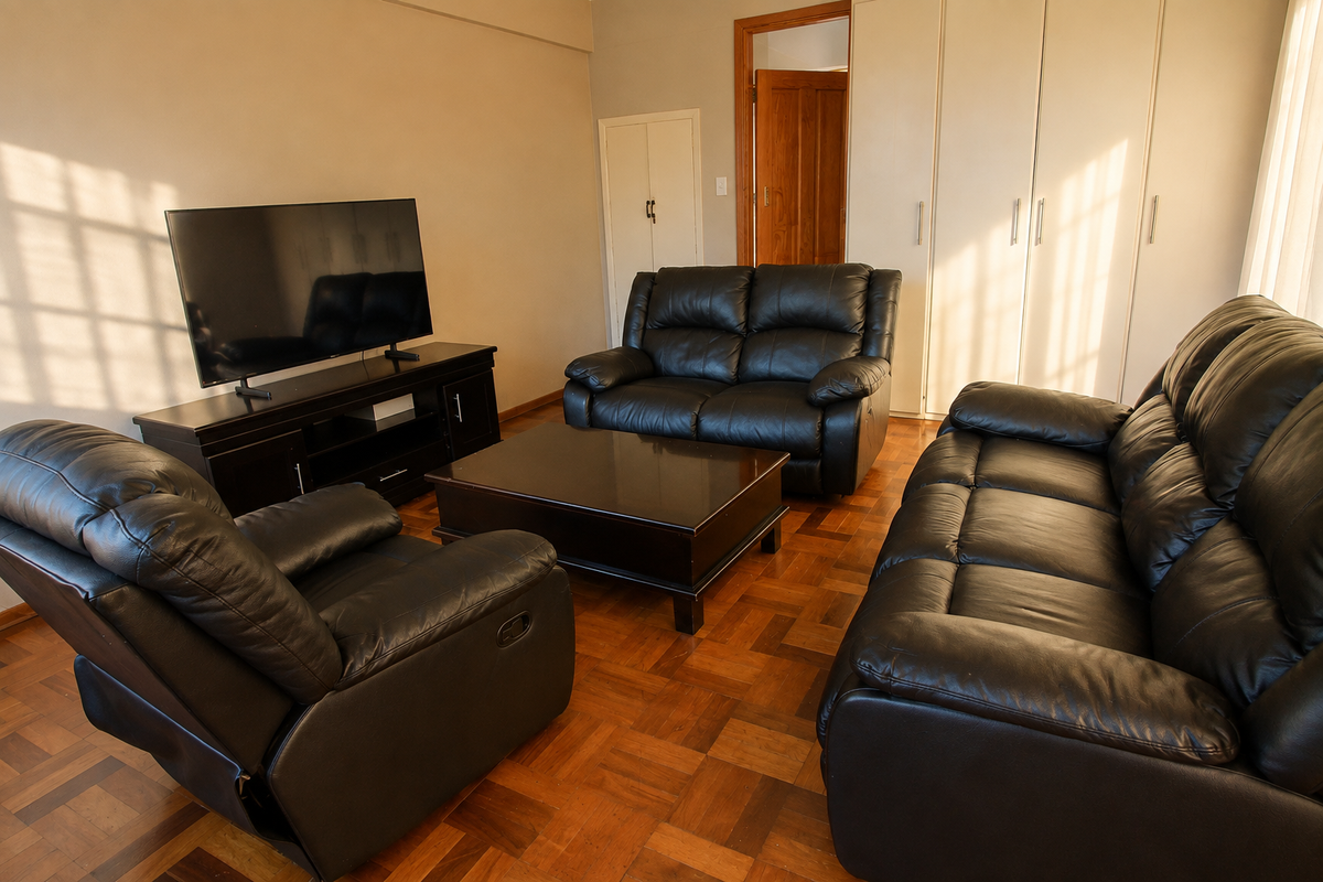 A living room featuring classic parquet flooring and extensive built-in storage cupboards, providing a functional and traditional living space.